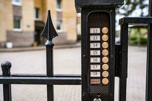 intercom panel with a video camera on the brick fence of private house photo