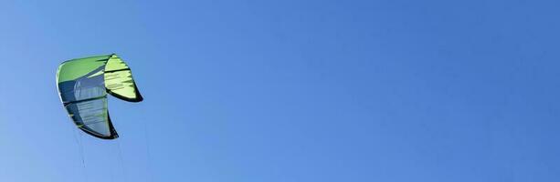 wing of kitesurfing against the blue sky . Banner photo