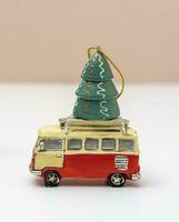 toy car is carrying a toy Christmas tree. Christmas tree and a minibus photo