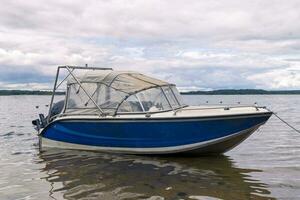 fishing motor boat standing near the shore on lake. boating, fishing photo