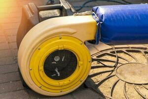 a blower for inflating a large trampoline in the park photo