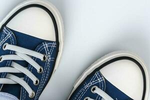 a pair of blue sneakers on a white background. Fashionable youth shoes photo