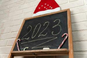 a black slate on which the year 2023 is written in chalk. Happy New Year. photo