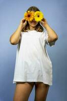 A happy pretty girl closes her eyes with yellow gerbera flowers photo