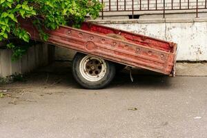 un antiguo coche carga remolque para un pasajero coche estacionado siguiente a el casa foto