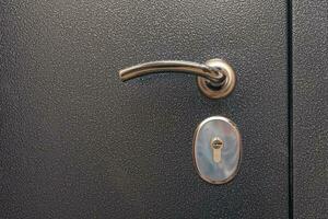 modern reliable metal door. shiny handle, lock. close-up. copy space photo