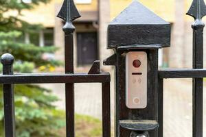 intercom panel with a video camera on the brick fence of private house photo