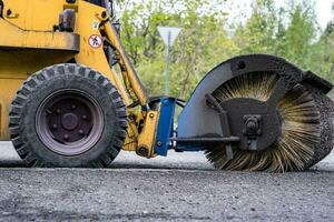 Cleaning of garbage from the road. a rotating mechanical machine brush photo