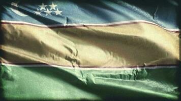retro envelhecido karakalpakstan bandeira acenando em a vento. velho vintage bandeira balançando em a brisa. desatado laço. video