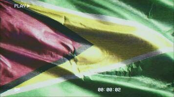 VHS video casette record Guyana flag waving on the wind. Glitch noise with time counter recording Guyanese banner swaying on the breeze. Seamless loop.