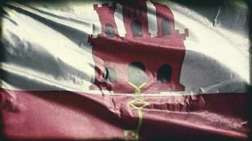 Retro aged Gibraltar flag waving on the wind. Old vintage banner swaying on the breeze. Seamless loop. video