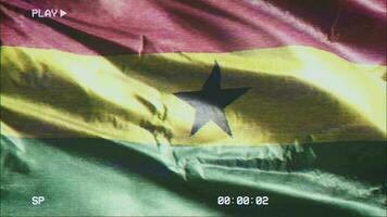 VHS video casette record Ghana flag waving on the wind. Glitch noise with time counter recording Ghanaian banner swaying on the breeze. Seamless loop.