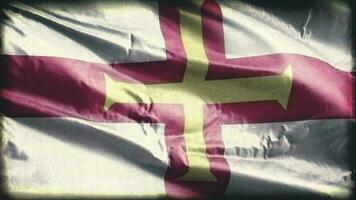 Retro aged Guernsey flag waving on the wind. Old vintage Gernian banner swaying on the breeze. Seamless loop. video