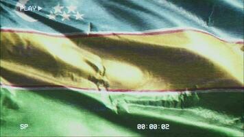 VHS video casette record Karakalpakstan flag waving on the wind. Glitch noise with time counter recording banner swaying on the breeze. Seamless loop.