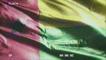 VHS video casette record Guinea Bissau flag waving on the wind. Glitch noise with time counter recording Guinea Bissau-Bissau banner swaying on the breeze. Seamless loop.