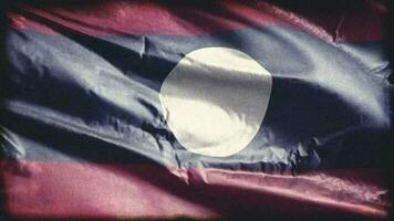 Retro aged Laos flag waving on the wind. Old vintage Laotian banner swaying on the breeze. Seamless loop. video
