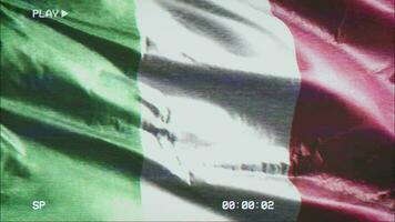 VHS video casette record Italy flag waving on the wind. Glitch noise with time counter recording Italian banner swaying on the breeze. Seamless loop.