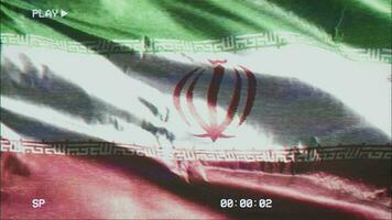 VHS video casette record Iran flag waving on the wind. Glitch noise with time counter recording banner swaying on the breeze. Seamless loop.