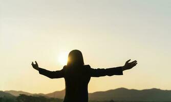 Happy businesswoman spreading arms and watching the mountain silhouette. Business success concept, freedom emotions photo