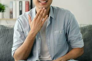 Happy young deaf man using sign Language to communicate with other people. photo