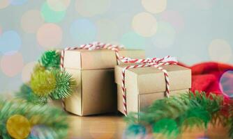 Christmas or Newyear gift box with tree branches and christmas decorations on wooden table, twinkling party lights bokeh background. photo