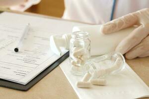 Pills in a glass bottle on a gynaecologists table photo