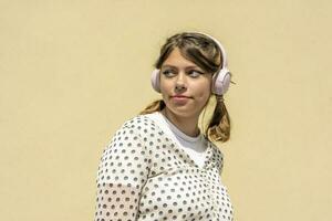 Adolescente linda niña tiene un bueno hora escuchando a música con auriculares. foto