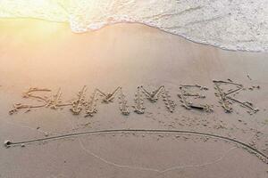 word Summer on the sand on the sea sandy beach in the sunset light photo