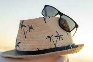 sun hat and sunglasses on a beach blanket. concept of summer holidays photo
