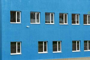 el pared de un nuevo azul casa con ventanas y un vigilancia cámara. foto