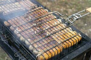 BBQ sausages on the grill. Fried sausages, chevapchichi Meat product photo