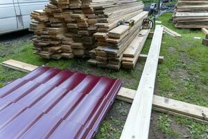 Wooden boards and roofing material stacked on the construction site photo