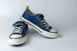 un par de azul zapatillas en un blanco antecedentes. de moda juventud Zapatos foto