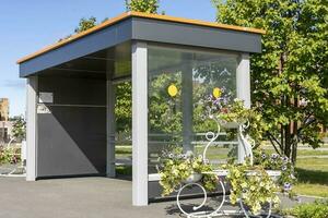 An empty bus stop decorated with beautiful flowers in pots and vases photo