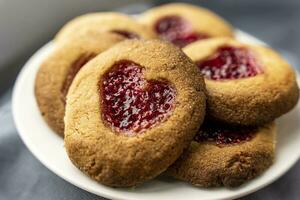 Homemade cookies decorated with raspberry jam in the shape of a heart photo