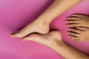 beautiful natural legs and arms of a teenage girl on a pink background photo