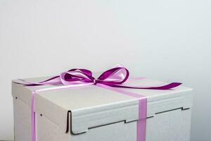 large white gift box tied with a red ribbon on a white background photo