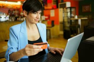 Adult woman using debit card for online payment photo