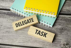 delegate task symbol. Concept words return on assets on wooden blocks. photo