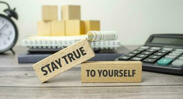 STAY TRUE TO YOURSELF is shown on a conceptual photo using wooden blocks