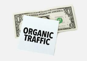 1 dollar bill and white notepad sheet on the white background. Text ORGANIC TRAFFIC photo