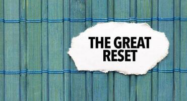 Text THE GREAT RESET on the piece of paper on the green wood background photo