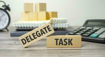 delegate task is shown on a conceptual photo using wooden blocks
