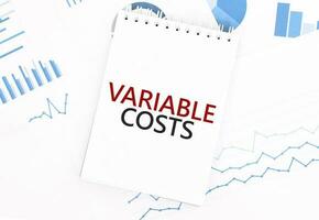 White notepad with text VARIABLE COSTS on the financial documentation. Finance and business concept photo