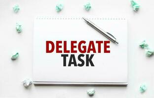 Blank sheet, pen and crumpled paper balls on grey table, flat lay. Text delegate task photo