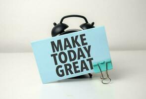 make today great is written in a blue sticker near a black alarm clock photo