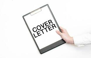 A businessman holds a folder with paper sheet with the text COVER LETTER. Business concept. photo