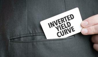 Card with INVERTED YIELD CURVE text in pocket of businessman suit. Investment and decisions business concept. photo