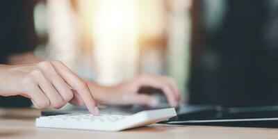 Businessman using a calculator to calculate numbers ,profit and loss statement review of company performance ,Cost analysis and calculation of financial documents ,business account checking photo
