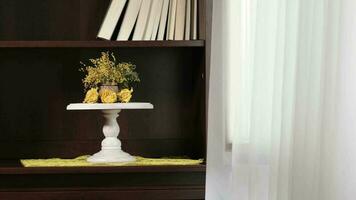 Mimosa flowers on a book shelf beside the window video